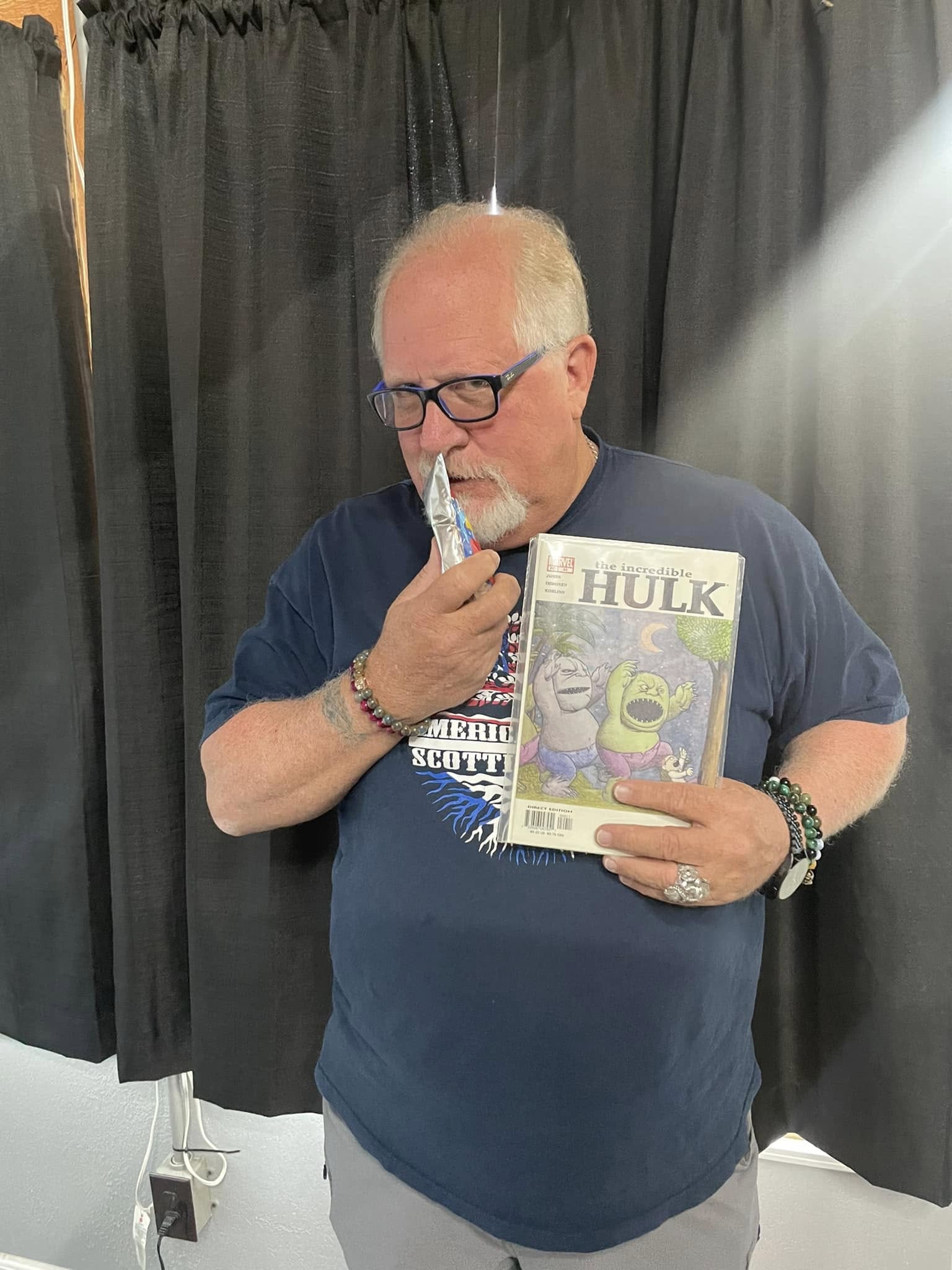 A collector holding an Incredible Hulk comic book