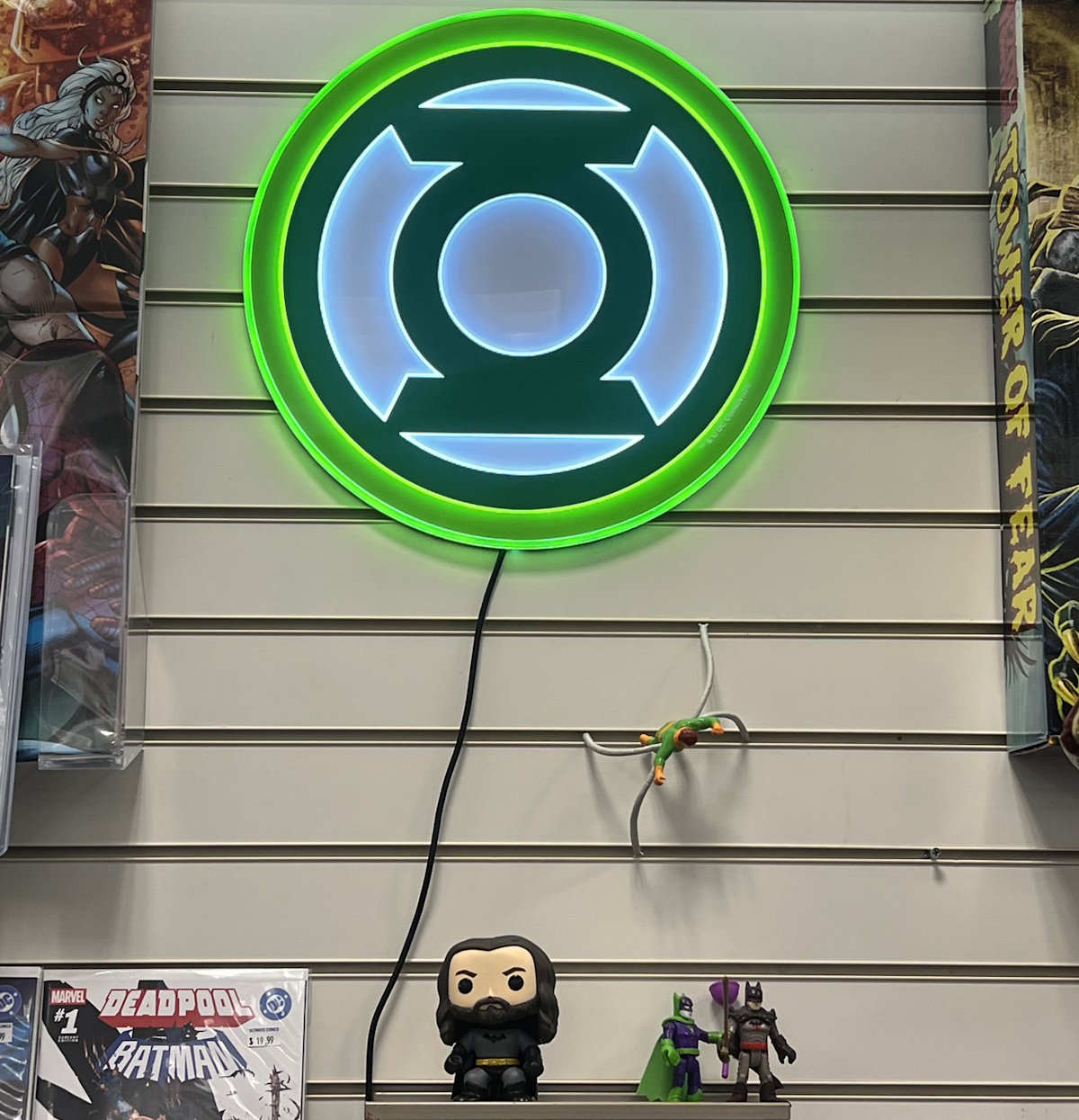 Green Lantern logo and collectibles displayed at Ultimate Comics Florida